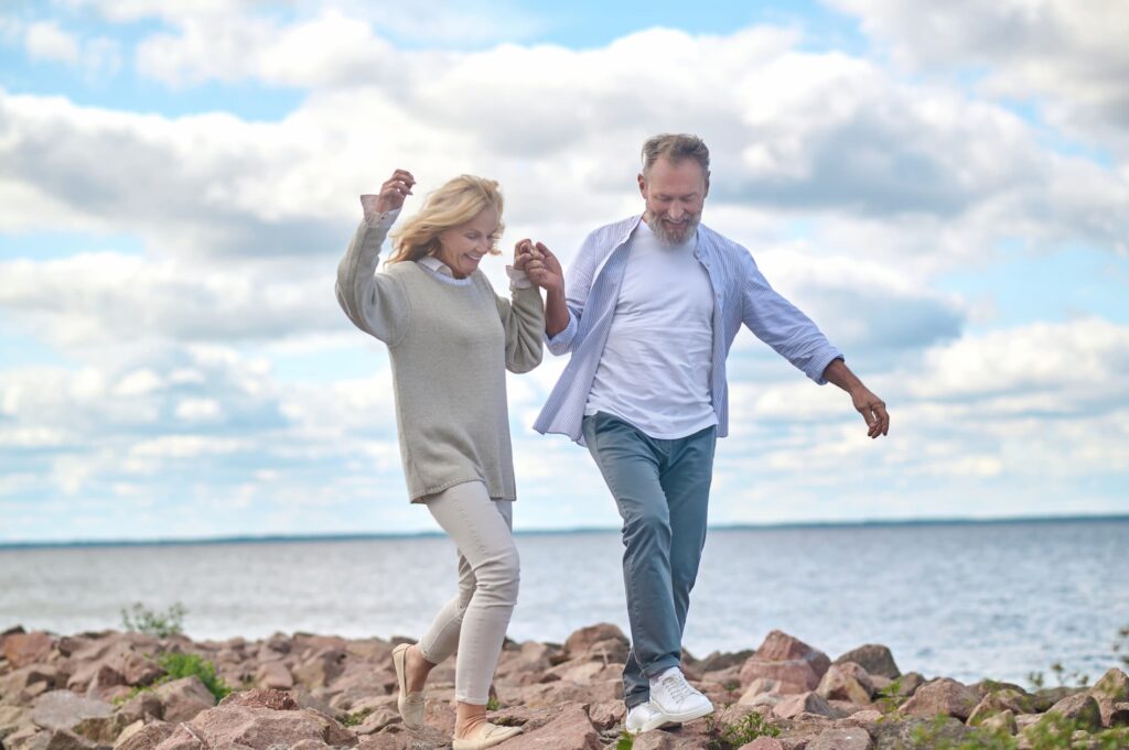 adult man and woman walking on seashore 1