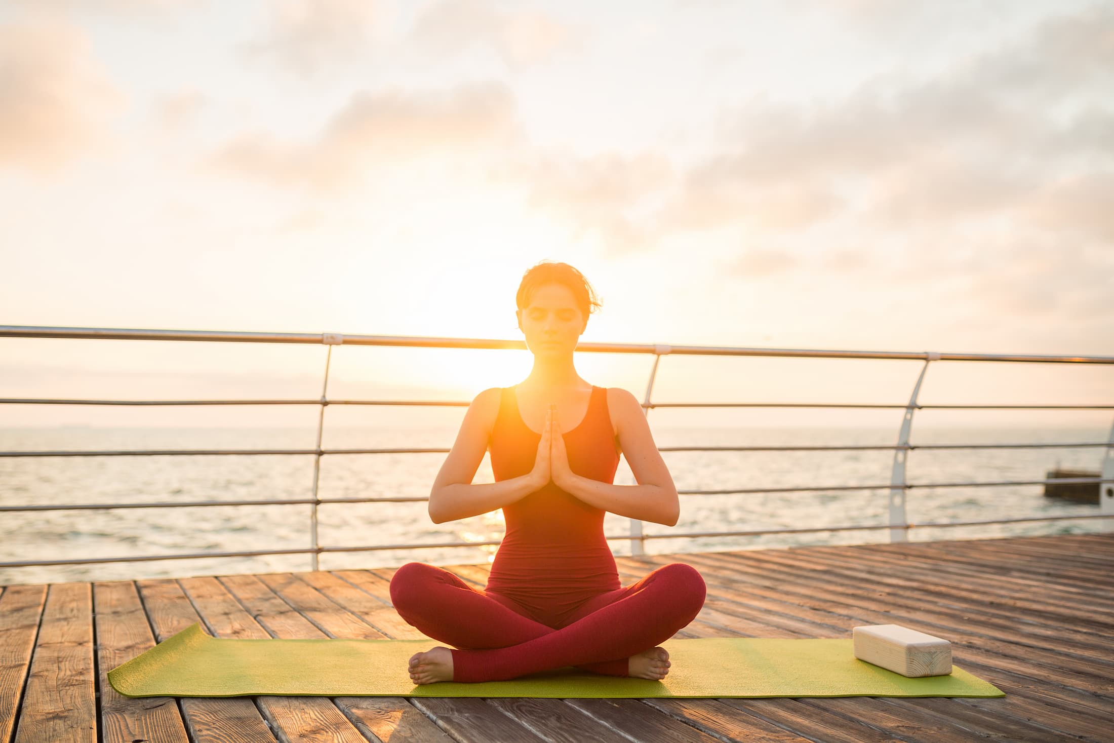 young slim beautiful attractive woman doing yoga in the morning on sunrise by sea healthy lifestyle 1